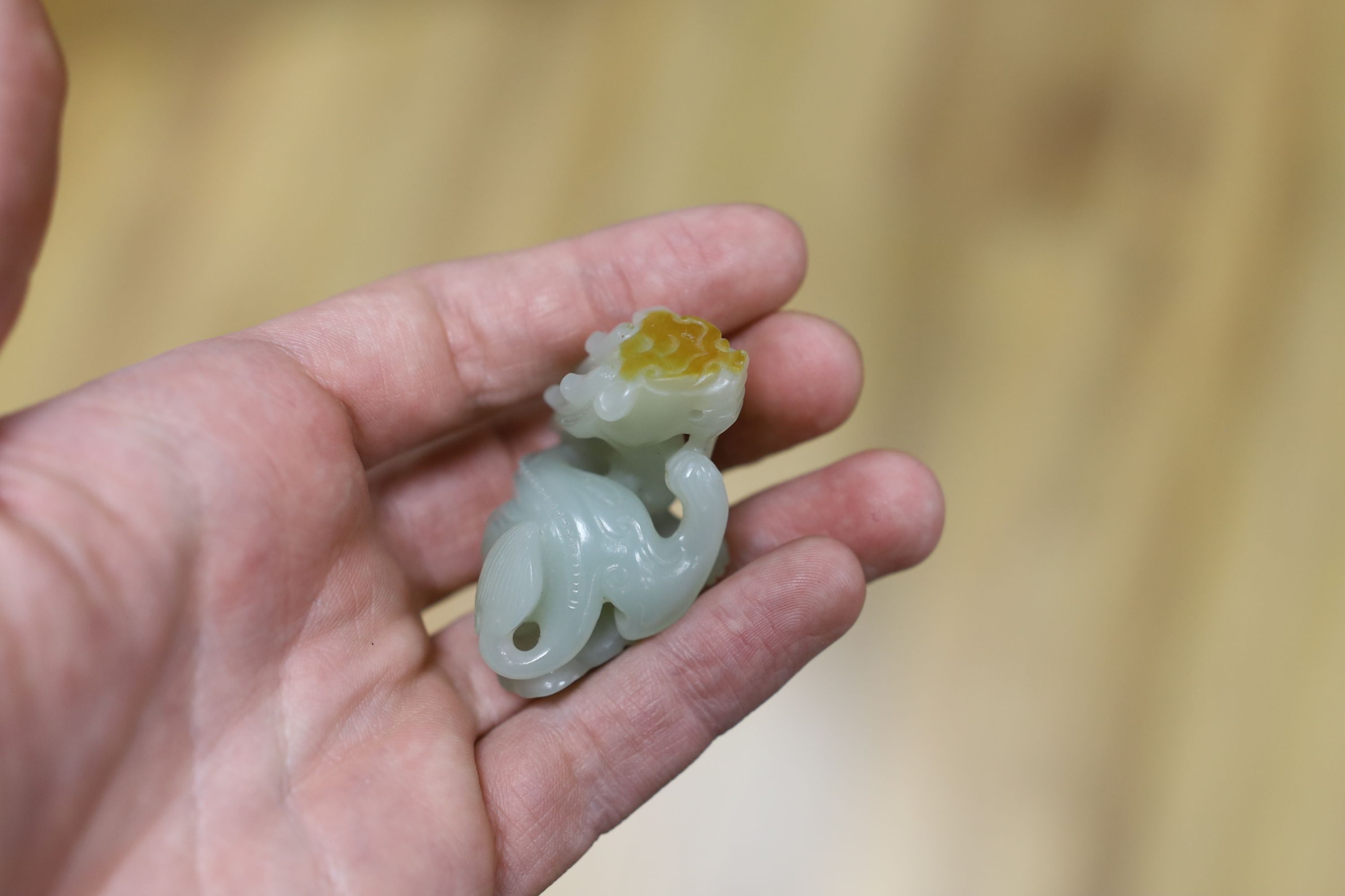 A Chinese pale celadon and russet skin jade figure of a dragon, 4cm high